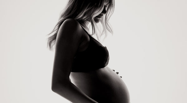 Foto de perfil de una mujer embarazada en ropa interior. ©Janko Ferlic para Unsplash.